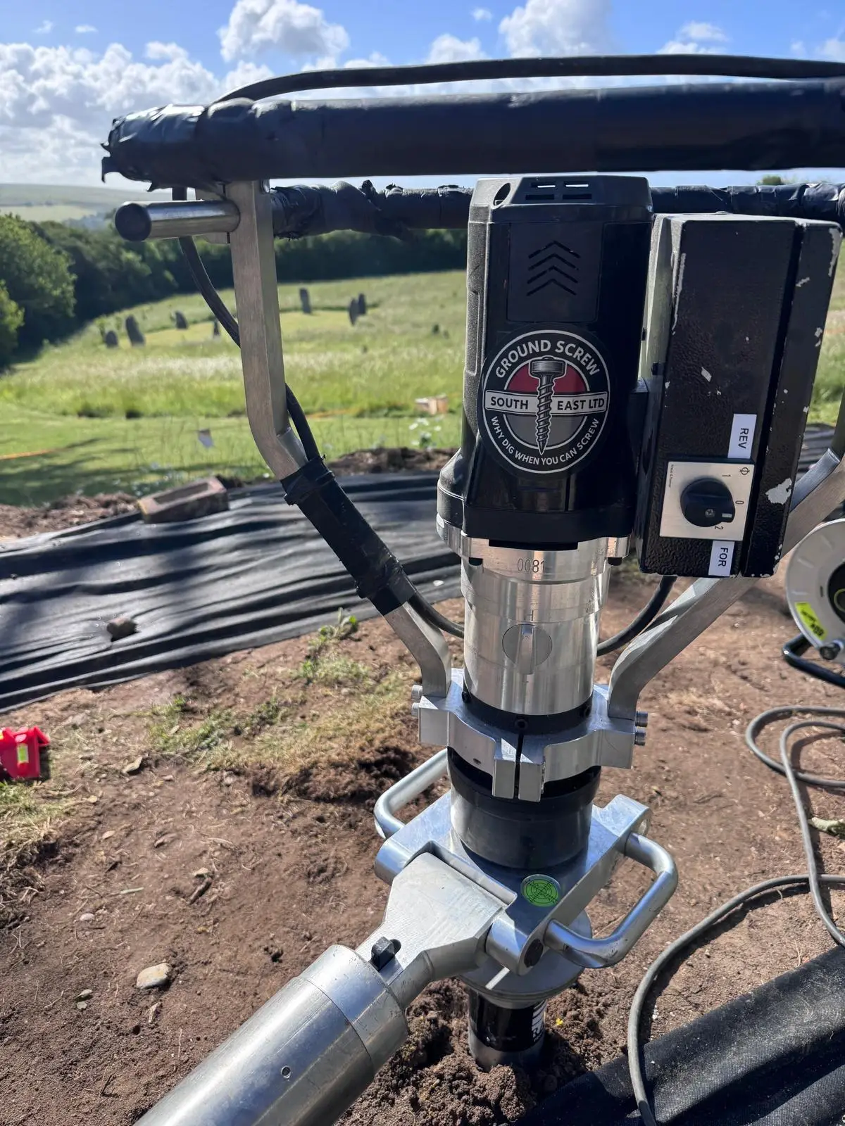 Ground screw pile being installed by hydraulic drive head